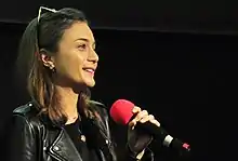 Turkish actress Damla Sönmez holding a microphone