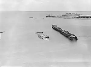 Darwin Harbour with the sunken ship MV Neptuna and burnt-out wharf of Naval Base Darwin following the attack on February 19, 1942