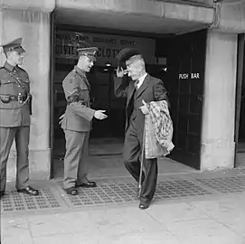 Mr Bill Krepper, late of the Pioneer Corps, leaves the demobilisation clothing depot at Olympia, London, as a civilian, wearing his demob suit.