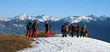 Dhauladhar ranges in the background; trekkers resting