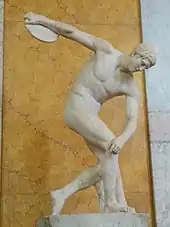 A discus thrower performs an isometric press by applying downward pressure onto his bent right leg. This allows the throw to be performed more powerfully.