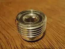 A screw plug to fit inside a DIN socket of a pillar valve. The central orifice is in the form of an Allen socket on the face which accepts the Yoke fitting. Both ends have face sealing O-ring grooves.