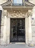 Metal and glass door between a pair of Ionic columns, in Paris