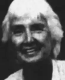 A smiling white woman with short white hair.