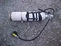 A diving cylinder ready for use on a British cave diving sidemount harness.