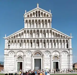 Pisa Cathedral, Italy. The entire building is faced with marble striped in white and grey. On the facade this pattern is overlaid with architectonic decoration of blind arcading below tiers of dwarf galleries. The three portals became increasingly common.