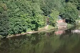 A picture of Durham School Boat Club's boat house in summer, taken from Prebends Bridge