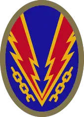 Oval shaped shoulder patch with a deep blue background. Lightning bolts break a yellow chain, representing the liberation of Nazi-occupied Europe.