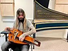 Hurdy Gurdy player Sergio González on an Early Music setting with a harpsichord in the back