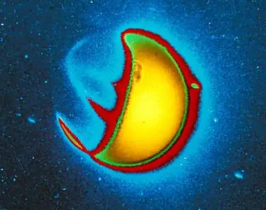 This is a picture of Earth in ultraviolet light, taken from the surface of the Moon. The day-side reflects a lot of UV light from the Sun, but the night-side shows bands of UV emission from the aurora caused by charged particles.