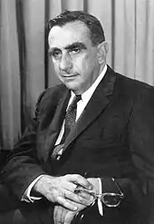 Head and shoulders of a man with bushy eyebrows.