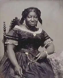 Black-and-white photograph of a black woman in mid 19th-century dress