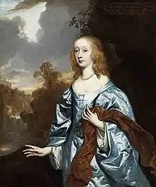 A young woman in a dramatic landscape setting, wearing a voluminous pale blue satin gown