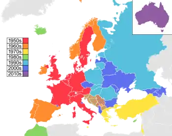Map of countries in Europe, North Africa and Western Asia, with Australia as an insert in the top-right corner, coloured to indicate the decade in which they first participated in the contest: 1950s in red, 1960s in orange, 1970s in yellow, 1980s in green; 1990s in sky blue; 2000s in blue; and 2010s in purple