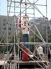 color image of the Phoenix 2 capsule held upright by scaffolds in a central square on display in Santiago, Chile