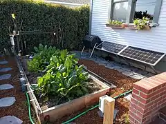 A FarmBot with a 100 watt solar panel, battery pack and compost bin.