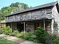 The Fletcher-Arnett Cabin is a two-story, two-pen log cabin built by Kelsey N. Fletcher and originally located near Lakeville in Magoffin County