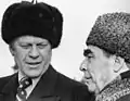 Gerald Ford (left) wearing an ushanka, with Leonid Brezhnev (right) who is wearing a gógol'&nbsp;[ru] (colloq. pirozhok) in 1974 in Vladivostok during the SALT I talks
