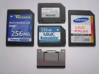 Front of four different MMC cards: MMC, RS-MMC, MMCplus, MMCmobile, and metal extender