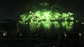 Screenshot from the episode, featuring the green "wildfire" explosion at night over a body of water