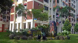 A stone with 'Gek Poh Ville' carved on it in Singapore's official languages