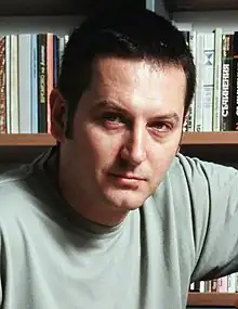 Author Georgi Gospodinov in front of a bookcase, circa 2005