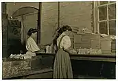 Two women packing glass in factory