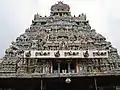 A 7-storey gopura with colorful figurines on each tier; with gods in center and other dolls on either side