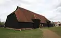 Grange barn, Coggeshall, England. This is a studded barn so the wall sheathing must be applied horizontally and covered with a siding material, in this case clapboards (weatherboards).