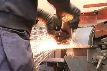 Man grinding a square tube.
