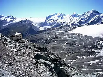 The west side as seen at a distance of 15&nbsp;km (9.3&nbsp;mi) from Hörnlihütte, at the foot of the Matterhorn, 3,260&nbsp;m (10,700&nbsp;ft) (in the back from left to right): Rimpfischhorn, Strahlhorn, Findelgletscher, Stockhorn (and Gornergrat below it), upper (on the north side) and lower (on the west side) Gornergletscher – the central Monte Rosa massif – Grenzgletscher, Liskamm and several Breithorn peaks on the south side (2008)