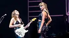 Taylor Swift and Alana Haim performing.