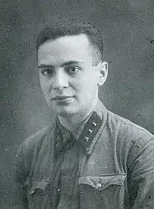 Black and white portrait photograph of a young man with short dark hair in military uniform with three studs on the collar