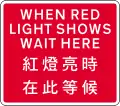 Used with temporary traffic signals. Vehicles must not proceed beyond the sign when red light shows.