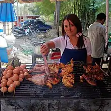 Chicken, pork and eggs being grilled at a small restaurant at the entrance of Huay Kaew waterfall, Chiang Mai, Thailand.