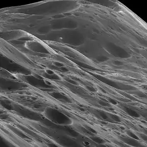 Image 8IapetusPhoto credit: Cassini orbiterA close-up of 10 km (6.2 mi) high mountains within the equatorial ridge on Saturn's moon Iapetus, photographed by the Cassini orbiter. Above the middle of the image can be seen a place where an impact has exposed the bright ice beneath the dark overlying material. The image was taken on September 10, 2007, with the Cassini spacecraft narrow-angle camera at a distance of approximately 3,870 km (2,400 mi) from Iapetus.More selected pictures
