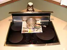 A pot of boiling water atop newspaper on an induction cooking surface