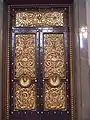 Bronze doors, designed by Cockerell, 12 feet 8 inches high by 6 feet 4 inches wide and weighs 74 cwt, there are three on each side of the hall, also three similar doors at the south end lead to the Crown Court and a smaller one is beneath the organ.