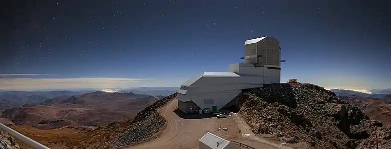 Night Light over Vera C. Rubin Observatory with the brightening of the sky due to the artificial light which can be seen as clusters of bright lights on the horizon.