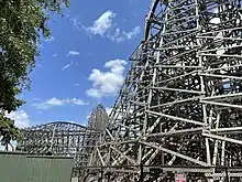 A view of Iron Gwazi's various support structure and track from a footpath in 2022. Most prominent in the background is the first outer-banked hill.