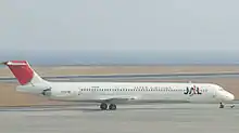 A McDonnell Douglas MD-81 aircraft taxiing on the tarmac, with a grey looking Seaview on the background