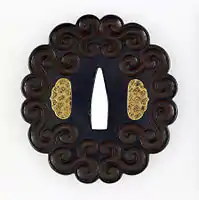 Japanese tsuba with geometric scrollwork design, not imitating plant forms