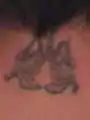Tattoo on the back of John Parsons' neck depicts two nude angels facing each other.