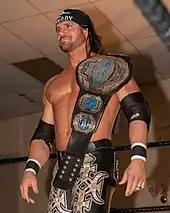 Johnny Impact with the fifth design of the belt, introduced in 2018, in its blue version.