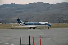 An aircraft located on a runway, with a mountain in the background