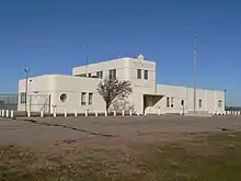 One-story building with two-story central section; rounded corners