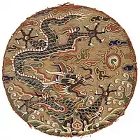 Roundel with five-clawed dragon design, Qing-dynasty China, late 17th century. Individual peacock feather barbules were placed, among silk and metal threads, to highlight the scales of the dragon. Metropolitan Museum, NYC.