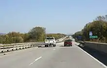 View from a divided highway with two lanes in each direction, with a pick-up truck and small car in front