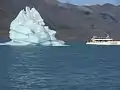 Iceberg and tourist boat on the lake