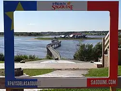 A footbridge leading to an island with a group of buildings